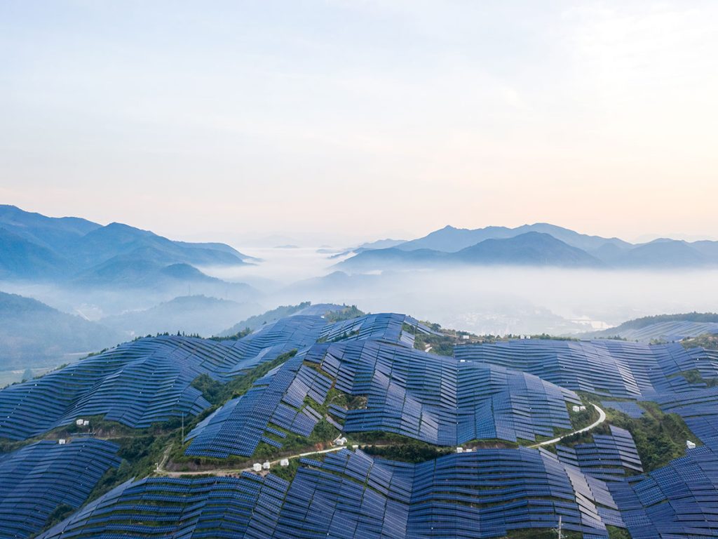 Solar farm spreading across a mountainside at dawn