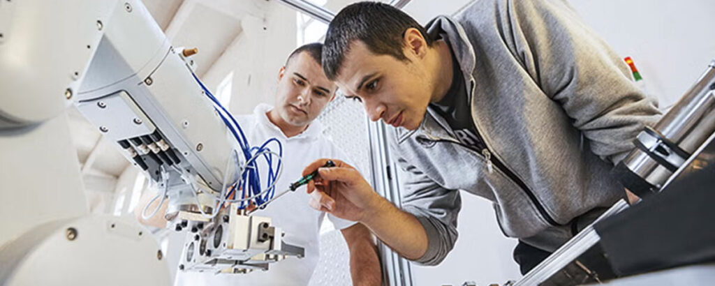 Two engineers work on a robot.