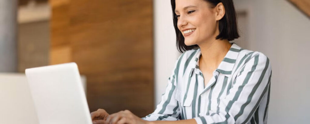 Person using a laptop while sitting at a desk